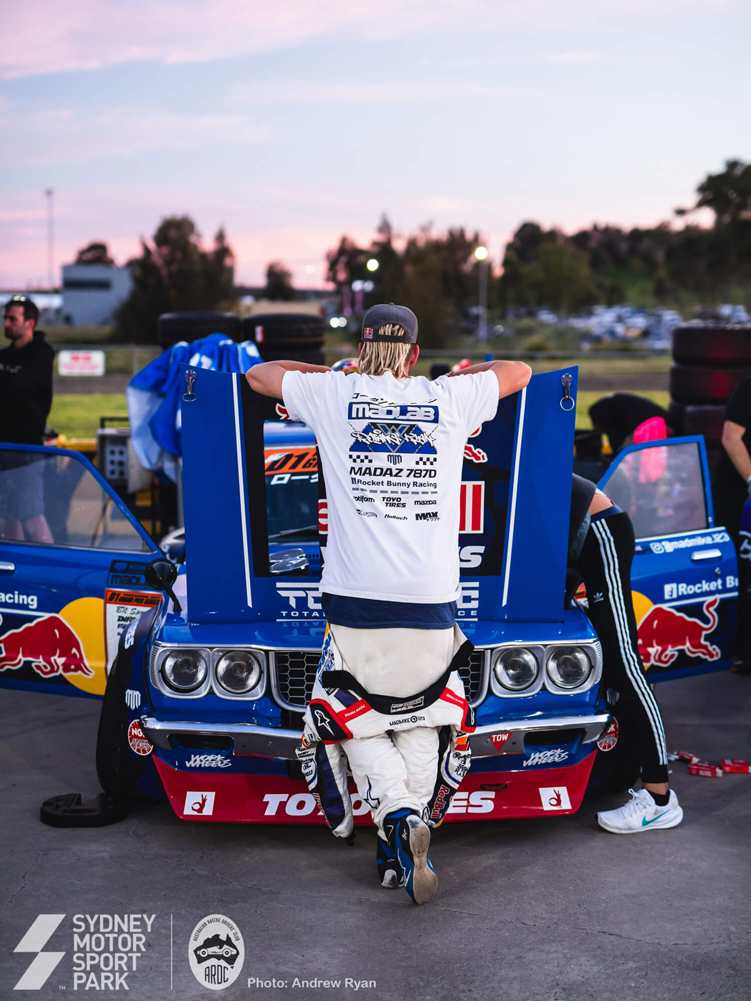 A crew working over a race car in an open garage