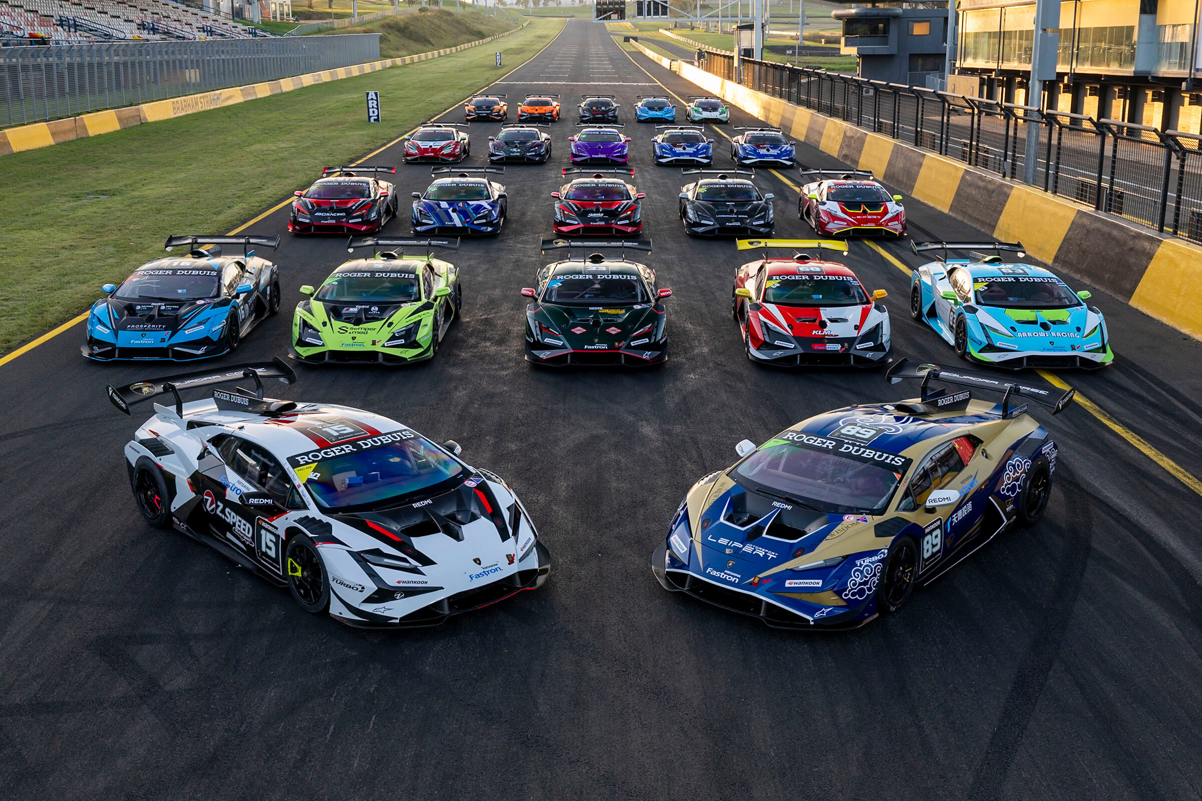 Race cars lined up on the main straight of Sydney Motorsport Park, grandstands either side